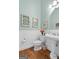 Charming bathroom featuring a pedestal sink, decorative windows, and white wainscoting at 127 Darwish Dr, Mcdonough, GA 30252