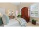 Bright bedroom featuring an antique armoire, daybed, neutral color scheme, and shuttered window at 127 Darwish Dr, Mcdonough, GA 30252