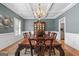 Elegant dining room with coffered ceiling, chandelier, and a large wooden table for formal gatherings at 127 Darwish Dr, Mcdonough, GA 30252