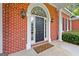 Close-up of the front door with sidelights, brick facade, exterior lights and a welcome mat at 127 Darwish Dr, Mcdonough, GA 30252