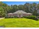 Charming brick home boasts a manicured lawn, lush greenery, and timeless architectural details at 127 Darwish Dr, Mcdonough, GA 30252