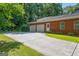 Exterior view of the brick house and detached two-car garage, plus long driveway at 127 Darwish Dr, Mcdonough, GA 30252