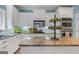 Elegant kitchen features granite countertops, white cabinetry, and stainless steel appliances at 127 Darwish Dr, Mcdonough, GA 30252