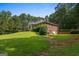 Rear view of a brick house featuring a lush lawn and surrounded by mature trees and well-maintained landscaping at 127 Darwish Dr, Mcdonough, GA 30252