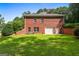 Back exterior of the brick home featuring an attached garage, outdoor space, and well-maintained landscaping at 127 Darwish Dr, Mcdonough, GA 30252