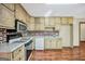 Cozy kitchen with white appliances, wood cabinets, and brick backsplash, offering functionality at 175 Laney Ct, Mcdonough, GA 30252