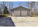 A sizable storage building, featuring a double roll-up door and pedestrian door, sits on a gravel foundation at 175 Laney Ct, Mcdonough, GA 30252
