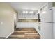 Well-lit kitchen featuring durable wood-look flooring, white cabinets, and ample shelving and cabinet storage at 758 King Rd, Jonesboro, GA 30236