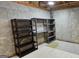 Unfinished basement with concrete walls and black metal shelving units at 1008 Stonekirk Trce, Lawrenceville, GA 30043