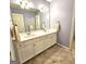 Bathroom featuring a double sink vanity, large mirror, neutral walls, and a tile floor at 1008 Stonekirk Trce, Lawrenceville, GA 30043