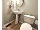 This bathroom features a pedestal sink, a decorative towel, and a toilet at 1008 Stonekirk Trce, Lawrenceville, GA 30043