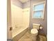 Bathroom with a bathtub, shower, toilet, white tile and a window at 1008 Stonekirk Trce, Lawrenceville, GA 30043