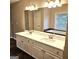 Bathroom featuring double sink vanity, sleek countertop, large mirror, and modern lighting at 1008 Stonekirk Trce, Lawrenceville, GA 30043