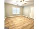 Spacious bedroom with wood-look flooring, a large window, and ample closet space at 1008 Stonekirk Trce, Lawrenceville, GA 30043