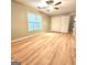This is a large bedroom with light-colored laminate floors and a ceiling fan with a light at 1008 Stonekirk Trce, Lawrenceville, GA 30043