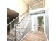 Bright foyer featuring a staircase, wood floors, and an open doorway to the living area at 1008 Stonekirk Trce, Lawrenceville, GA 30043