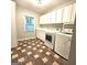 This laundry room features a tile floor, plenty of cabinet storage, as well as a washer and dryer at 1008 Stonekirk Trce, Lawrenceville, GA 30043