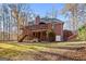 Spacious backyard featuring a large brick home with a wooden deck and stairs, perfect for outdoor living at 340 Antebellum Way, Fayetteville, GA 30215