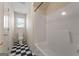 Bathroom with black and white tile flooring, tub/shower, and window for natural light at 340 Antebellum Way, Fayetteville, GA 30215