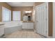 Bright bathroom featuring a tiled corner tub, granite counters, and white cabinets at 340 Antebellum Way, Fayetteville, GA 30215