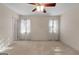 Spacious bedroom with neutral tones, two windows, a ceiling fan, and carpet flooring at 340 Antebellum Way, Fayetteville, GA 30215