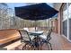 Close up shot of wooden deck showing an outdoor table set covered by an umbrella at 340 Antebellum Way, Fayetteville, GA 30215