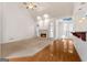 Spacious living room with fireplace, hardwood floors, large windows, and adjacent kitchen area at 340 Antebellum Way, Fayetteville, GA 30215