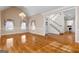 Open floor plan featuring wood floors and large windows with custom floral-patterned drapery, leading to staircase and entry at 340 Antebellum Way, Fayetteville, GA 30215