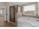 Bright bathroom boasts a garden tub, and separate glass shower and natural light at 1225 Polk Xing, Mcdonough, GA 30252
