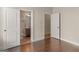 Well-lit bedroom offers hardwood floors and two open doorways showing adjacent rooms at 1225 Polk Xing, Mcdonough, GA 30252