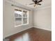 Bright bedroom features hardwood floors, a ceiling fan and a large window bringing in natural light at 1225 Polk Xing, Mcdonough, GA 30252