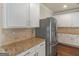 Close-up of kitchen features white cabinets, stainless steel appliances and granite countertops at 1225 Polk Xing, Mcdonough, GA 30252