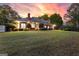 Expansive backyard with a well-maintained lawn, seating, and brick exterior at dusk at 248 Montrose Dr, Mcdonough, GA 30253