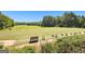 Driving range with a bench and tee box stations set amidst mature trees at 248 Montrose Dr, Mcdonough, GA 30253