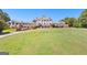Stunning exterior view of a grand building overlooking lush green lawns and beautifully landscaped grounds at 248 Montrose Dr, Mcdonough, GA 30253