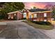 Elegant brick home with manicured landscaping, driveway, and warm exterior lighting at sunset at 248 Montrose Dr, Mcdonough, GA 30253
