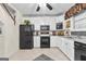 Well-lit kitchen with black appliances, white cabinets, and a ceiling fan, providing a comfortable cooking space at 248 Montrose Dr, Mcdonough, GA 30253