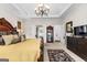 Main bedroom with tray ceiling, chandelier, and decorative furnishings at 248 Montrose Dr, Mcdonough, GA 30253