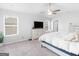 Bright bedroom featuring a ceiling fan, plush carpet, and a large window at 445 Sawmill Trce, Hampton, GA 30228