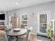 Bright dining area with a round table, upholstered chairs, natural light, and backyard access at 445 Sawmill Trce, Hampton, GA 30228