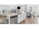 Modern kitchen featuring a central island with a sink, stainless steel appliances and an open view into living area at 445 Sawmill Trce, Hampton, GA 30228