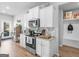 Bright kitchen with white cabinetry, stainless steel appliances, and wood floors in neutral color palette at 445 Sawmill Trce, Hampton, GA 30228