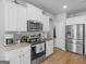 Modern kitchen featuring stainless steel appliances, granite countertops, white cabinets and light wood floors at 445 Sawmill Trce, Hampton, GA 30228