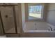 Bathroom featuring separate shower and tub with large picture window overlooking the yard at 746 S. Bethany Rd., Locust Grove, GA 30248