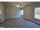 Bright bedroom with neutral walls, soft carpeting, a ceiling fan, and natural light from the windows at 746 S. Bethany Rd., Locust Grove, GA 30248