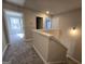 Upstairs hallway featuring neutral paint, plush carpet, and open doorway to a bedroom at 746 S. Bethany Rd., Locust Grove, GA 30248