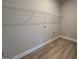 Convenient laundry room with utility connections, wire shelving, and wood-look flooring for a tidy space at 746 S. Bethany Rd., Locust Grove, GA 30248