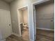 Hallway view of laundry area with wire shelving and a half bath featuring a gray vanity and wood-look flooring at 746 S. Bethany Rd., Locust Grove, GA 30248