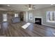 Open-concept living room with fireplace, vinyl floors, and bright natural light from large windows at 746 S. Bethany Rd., Locust Grove, GA 30248