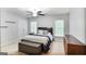 Bright bedroom featuring soft neutral walls, a ceiling fan, windows and a well-made bed at 2770 Stonehill Way, Cumming, GA 30041